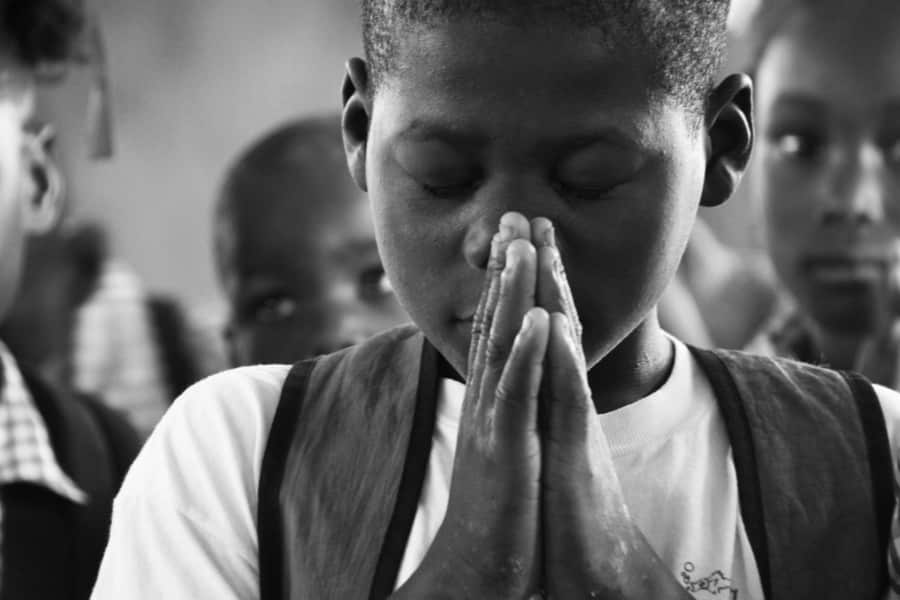 Child prays in Haiti
