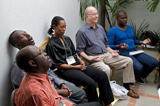 Small group meditates and practices breathing exercises 