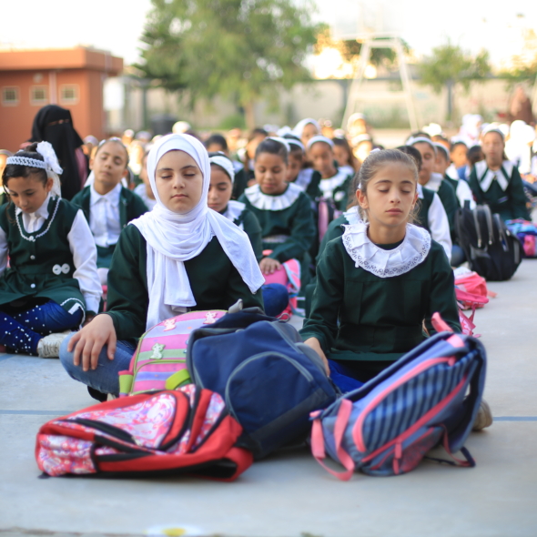 Young students meditate in the queue before school in Gaza